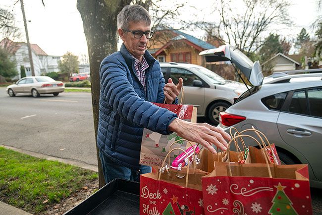Rusty Rae/News-Register##Jack Pattishall loads gift bags into his vehicle in preparation for driving his Meals on Wheels delivery route. Pattishall spent 20 years in the Navy and another 20 with the post office in the Boston area before moving to McMinnville to be closer to family.