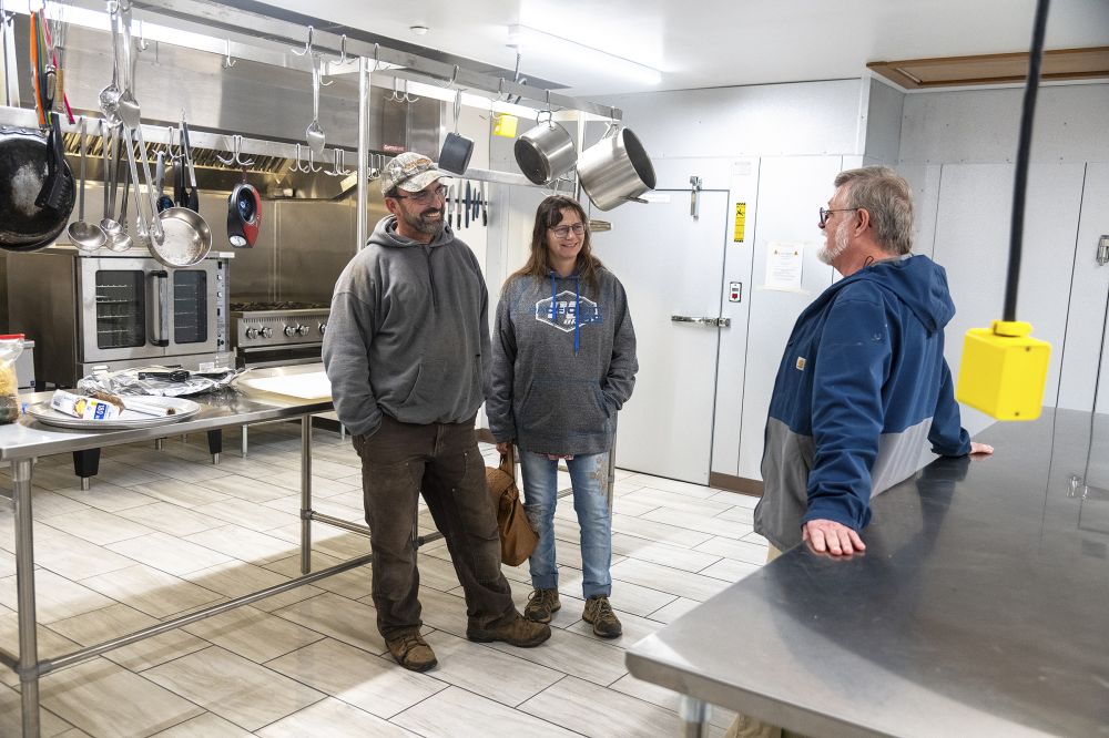 Rusty Rae/News-Register##Bret and Serena Martin of Sheridan, left, talk with board chair Tim Beevers in the new commercial kitchen at the Yamhill County Gospel Rescue Mission. The Martins spoke with Beevers about ways the church they attend in McMinnville might engage with the mission and its services. Cofounder and chef/kitchen manager Terry Woods said, “the kitchen is a blessing. I am so eager to put it to full use,” once building occupancy is official in February.