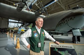 Rachel Thompson/News-Register##Bud Varty has been giving tours of World War II planes such as the Messerschmidt jet for 15 years. He loves meeting visitors and learning about the history of the planes, often from people who flew or worked on them.