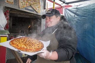 Rusty Rae/News-Register##Keely Avila Gigoux lifts a freshly cooked pie from the wood-fire oven in her food truck, Hook & Ladder Pizza, which is built into a retired fire engine. Hook & Ladder parks at Lowe’s in McMinnville Thursday, Saturday, Sunday and Monday.