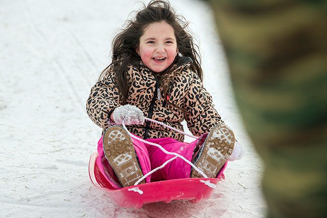 ##With a bright sled, warm outfit and big smile, Charleigh Britt enjoys a rare chance to whoosh down a snowy hillside in her hometown.