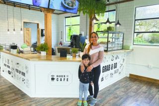 Starla Pointer/News-Register##Fon Khunsamart and her youngest son, Asher, show off the new Baker Street Cafe at 205 S.E. Baker St., McMinnville. A native of Thailand, Khunsamart offers several Thai entrees. Her husband, Thomas Gilstrap, bakes pastries such as brownies, big cookies, cinnamon rolls and a variety of Danishes.