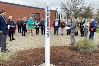Starla Pointer/News-Register##Presbyterian Church pastor Matt Johnson speaks at the dedication of a Peace Pole on the McMinnville church grounds. About 30 members of the congregation attended Sunday’s event. The pole reads “May peace prevail on earth” in four languages.