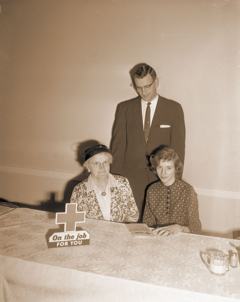 ##(Feb. 26, 1959) The wonderful results of the Red Cross blood program are illustrated in Susan Werth, right, at the Red Cross drive kickoff luncheon Tuesday. Mrs. Guy Sully of McMinnville also knows what the Red Cross means, according to Glen C. Macy, standing, local chapter chairman. Mrs. Sully has a service record with the local chapter stretching back to World War One.