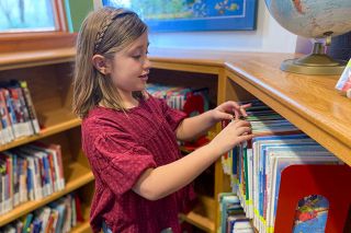 Starla Pointer/News-Register##Della Harris, 8, looks for Fancy Nancy titles and other books to check out. She often visits the McMinnville Public Library after classes at St. James School in the company of her grandmother, Jeanette Bernards.