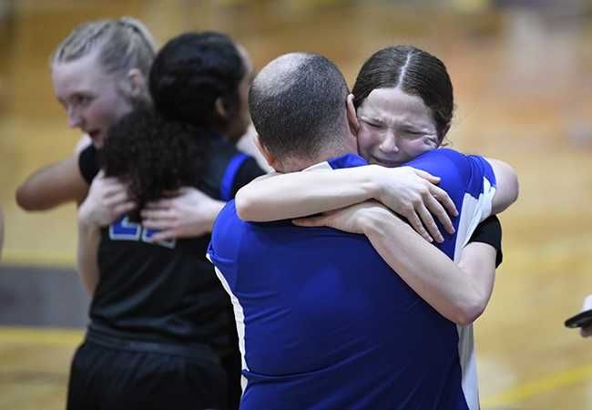 Rusty Rae/News-Register##Amity guard Alyssa McMullen hugs dad and Amity head coach Jed McMullen after winning against Sutherlin.