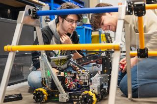 Rusty Rae/News-Register##Ben Weisz, left, and Josh Phillips of the Ursa Mechanica McMinnville High School robotics team review the mechanics of their robot in preparation for the state competition in Hillsboro on Sunday.
