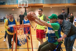 Rachel Thompson/News-Register##Larry McMinn, of McMinnville, scores a basket with the help of Danny Lynn of Dallas. Lynn is an enclave supervisor at MV Advancements in Polk County. Behind them, from left: Brittany Painter from Amity, Jay Siemer from Newberg, Addie Belinsky from Dayton and Steven Whittenburge from Willamina.