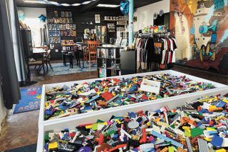 Kirby Neumann-Rea/News-Register##Large tables filled with myriad Lego pieces, for sale in bulk, take up one corner of the Mana Cloud space in Lafayette. Gaming tables, merchandise racks and an imaginative mural by Hugh Newell help set the scene.