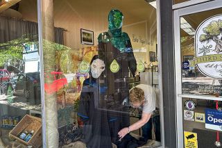 Kirby Neumann-Rea/News-Register##Renita Hansen of Third Street Oil and Vinegar sets up the store’s annual display of alien visitors and spacecraft.