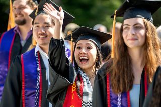 Rachel Thompson/News-Register##Nursing major Tran Ngo waves excitedly during the procession into the Linfield graduation ceremony.