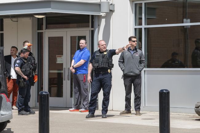 Rusty Rae/News-Register##
McMinnville High School Principal Dave Furman, center, and the district s facility director, Brian Crain, right, talk with McMinnville police officers outside the main entrance at noon Tuesday. Police responded to a  swatting call,  a false report designed to bring about a law enforcement response.