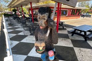 Kirby Neumann-Rea/News-Register##Alf’s monkey sculpture on the checkered patio holds hefty burger in his paw and yummy strawberry cone in his tail.