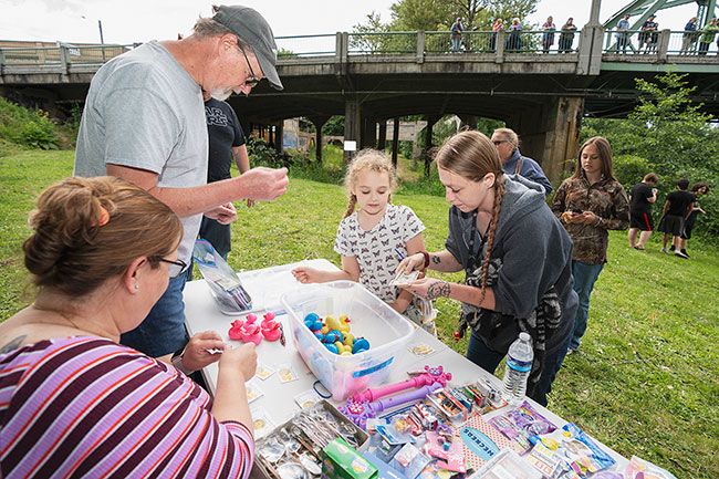 Rachel Thompson/News-Register##Jenny Marler and her daughter, Athena, of Willamina, buy tickets for five plastic ducks — Athena specified she wanted pink — prior to the June 15 Sheridan Hometown Days Duckie Race on the Yamhill River. Helping them are Colin Geyens, standing, and Jennifer Stanislaw, wife of Sheridan Rotarian John Stanislaw.