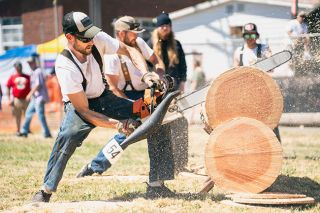 Rachel Thompson/News-Register##Ryen Shelton, foreground, from Willamina, competes with Shane Felton, from Grand Ronde in the Willamina July 4 logging show, held at West Valley Community Campus, one of the main events in the town’s many-faceted Independence Day activities.