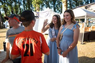 Rachel Thompson/News-Register##Queen Adelle Petratis, center, and Princess Maddy Tuning greet people on Friday night in Beulah Park during Yamhill Derby Days coronation festivities. They’d just run into Whitley Wolcott, 6, who had exclaimed, “I can’t believe I met a real princess!” Such interactions “make it all worth it,” Adelle said. Her mother, Shavaghn Petratis, and her brother, Joe, are pictured at left.