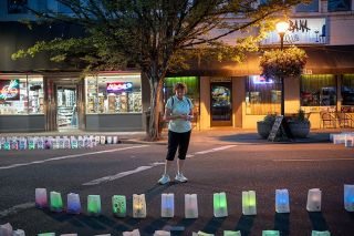 Rachel Thompson/News-Register##essica Binkerd takes a look at luminaria honoring cancer victims during the July 20 “Light Up the Night for Hope,” on Third Street, part of the American Cancer Society Relay for Life activities in Yamhill County this year. Binkerd came to the event with a friend who lost her son at 17 due to an aggressive cancer; she also honored several of her own family members. The luminaria event and silent auction went well despite the heat, said Melissa Hernandez of the Relay for Life Committee.