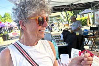 Kirby Neumann-Rea/News-Register##Mariette Van Tilburg, visiting from the Netherlands, samples cheese at the Briar Rose Creamery stand at the McMinnville Farmers Market.