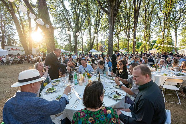 Rachel Thompson/News-Register##Decorative lighting among the trees and natural twilight in Linfield’s oak grove create ambiance at the July 26 Grand Dinner, one of the main events of IPNC. An international array of winemakers and other industry speakers, chefs and hospitality providers from around the Northwest led educational seminars, tastings and other culinary experiences for attendees at the July 26-28 event.