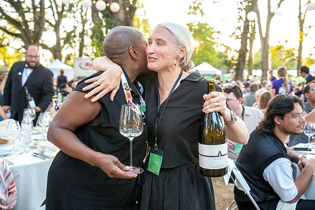 Rachel Thompson/News-Register##Two friends hold wine and embrace each other during the 28th annual International Pinot Noir Celebration (IPNC) Grand Dinner July 26 at Linfield University. Julie Coney, left, is a wine consultant for American Airlines, based in Washington, D.C. and Houston. Kate Payne Brown, right, from McMinnville, is a winemaker at Ambar Estate, Newberg. The two share a love for sparkling wine and have been friends since 2018 or 2019, when they met at a wine event where both were speakers. Since then, they’ve seen each other at wine events including in the Champagne region of France. “We’ve been so fortunate to meet in different places and share a love for wine,” Brown said.