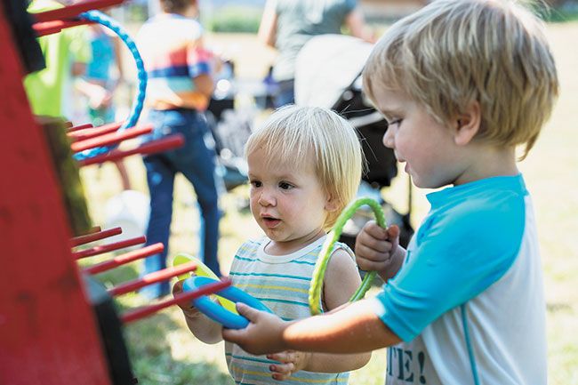 Rachel Thompson/News-Register##Caspian Byler, 22 months, and his brother Pierson Byler, 3, of Junction City, play a ring toss game, one of many children’s activities Saturday. The boys came to the Fun Festival with their family, who brought pies for the dessert table.