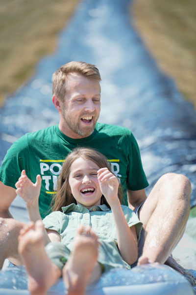 Rachel Thompson/News-Register##Michael Ober of Portland and his daughter, Hailey Ober, 12, enjoy the water slide at Rock of Ages during the retirement center’s annual community fun festival. Rachel Thompson/News-Register