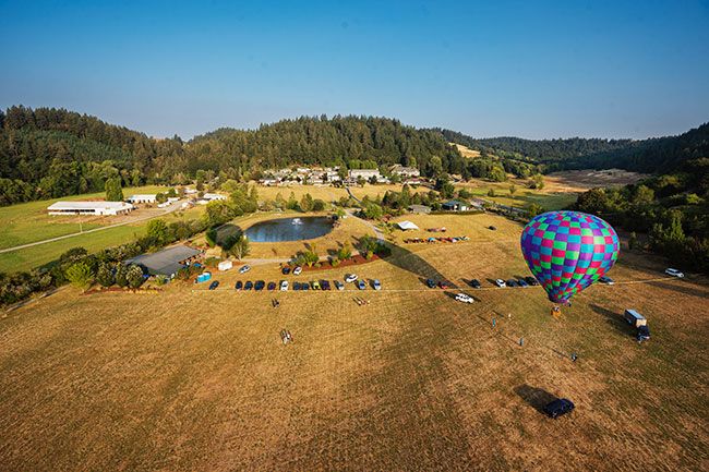 Rachel Thompson/News-Register##Seen from a hot air balloon 300 feet in the air, the Rock of Ages/Valley View campus southwest of McMinnville gets ready for Saturday’s Fun Festival. The checkered balloon, “Heaven Bound Too” piloted by Chris Whitfield of Albany, stayed at the festival for tethered rides while three others flew out over the countryside at dawn. The festival drew hundreds of people throughout the day.