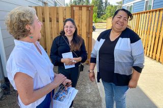 Starla Pointer/News-Register##Habitat Board President Patty Haddeland, left, talks with new homeowner Melva Martinez, right, who said she is thrilled to have a home of her own. Between them is Laura Bruce, an interpreter who helped with Spanish translation during a dedication ceremony for Martinez&rsquo;s home and three others on Sunday.