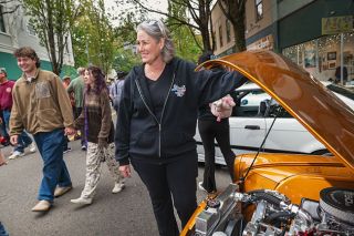 Rusty Rae/News-Register##Janette Thornley shows off the new Chevy engine in her 1958 English Ford Anglia during the Cruising McMinnville car show Saturday on Third Street. Her father bought the fixer-upper for $25 in the early 1970s but died before he could restore it; she had it restored in North Carolina, where she now lives, and brought it to her hometown for the Cruising event.