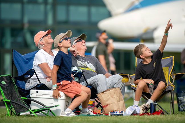 Rachel Thompson/News-Register##Laura and Bob Smith of Eugene and their grandchildren revel in the sight and sound of roaring Thunderbirds from their vantage point Sunday at Evergreen museum. Avery Sholian, 11, pointing at right, said his favorite plane is the Blackbird. Xavier Smith, 9, left, said he loves the Blue Angels. Bob said, “Great show.” The Smiths attended air shows some 30 years ago at Creswell, south of Eugene, but this was their first visit to the McMinnville aviation extravaganza. They said the family’s favorite part is “the really loud planes.”