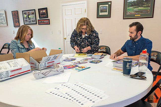 Rusty Rae/News-Register##Angie Yocum, advisor to the Mac High Key Club, left, prepares children’s books along with Sandy Williams and David Toth of the McMinnville Kiwanis Club. The group held a work party recently to get the books ready.