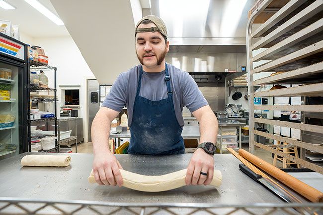 Rachel Thompson/News-Register##Danicic, general manager of the Carlton Bakery, sets a roll of buttery croissant dough on his stainless steel work table about 5:15 a.m. He will spread out the thin dough and cut it into triangles, which he’ll then roll into croissant shapes.