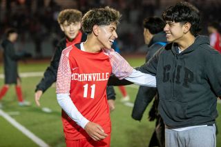 Rusty Rae/News-Register##Edwin Cuevas-George, left, celebrates with teammate, and brother, Abraham, after the Mac boys secured a spot in the state semifinals.