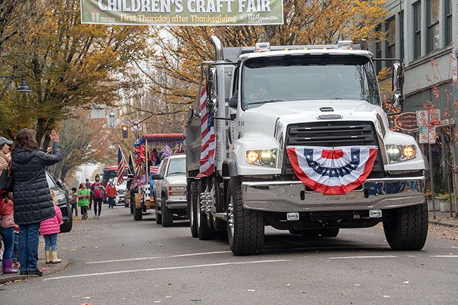 Rachel Thompson/News-Register##A Yamhill County Public Works dump truck is decked out in red, white and blue for the parade. Public Works employee Jack Blanchard, a Marine veteran, drove the truck with passenger Commissioner Kit Johnston handing out candy.