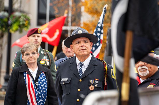 Rachel Thompson/News-Register##Veterans in uniform and numerous community groups as well as individuals filled Third Street on Saturday morning for the annual McMinnville Veterans Day parade, followed by a ceremony at Oregon Mutual Insurance parking lot. United Veterans Honor Guard Commander Angel Mendoza, the parade organizer, and Debra Godwin, American Legion Auxiliary past state president, listen to speakers including Grand Marshal Stan deStwolinski. The post-parade ceremony started with “Taps” in honor of fallen service members and first responders.