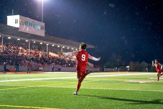 Rachel Thompson/News-Register##Junior forward Jose “Joey” Farias runs toward the Wortman Stadium fans in celebration after scoring what would be the winning goal in Tuesday night’s semifinal matchup against Grant. Farias’ teammates rushed to the sidelines to cheer with him and the home crowd, including Edwin Cuevas-George, right, who took the free kick that bounced off the Grant goalkeeper and led to the goal.