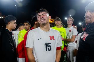 Rachel Thompson/News-Register##McMinnville senior midfielder Adan Figueroa Lampke expresses the anguish of defeat following the Grizzlies’ 3-2 loss to Jesuit in the OSAA 6A state soccer final game Saturday at Hillsboro Stadium. Lampke, along with other players and coaches, turns during an emotional post-game huddle to see teammate Isai Cuevas-George on the ground.