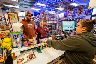 Rachel Thompson/News-Register##Jessi Adrian, right, rents movies to Derek Peterson, left, and Stephanie Burris, center, who said they visit the Reel Hollywood Video at least every other week, if not weekly. They are impressed to be able to rent movies “like you used to,” Adrian said. This time, they also picked up some drinks from the walk-in cooler.