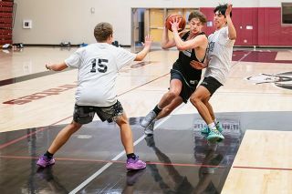 Rusty Rae/News-Register##Senior Lane Garrison drive toward the basket as Michael McGrew (15) and Victor Nambo try to cut him off.