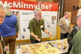 Scott Unger/News-Register##Scott Edwards Architecture Principal Jesse Graden explains potential layouts for the redevelopment of the former Ultimate RB site. Graden’s team provided wooden blocks representing different site elements such as residential, commercial and parking for residents to arrange.