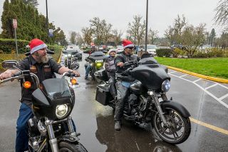 Rusty Rae/News-Register##BC Harleys members Charlie Wallin, left, Cody Lowe, center, and Scott Edwards, right, with his son, Carter, and others from the motorcycle racing organization roar up to Willamette Valley Medical Center Dec. 12 to deliver 150 new toys for the hospital to give to new mothers in the birthing center and children who come to the emergency room throughout the year. David Stevens, who formed the group, said this was its first year to collect toys; next year, members plan to give toys to both WVMC and Doernbecher Children&rsquo;s Hospital.