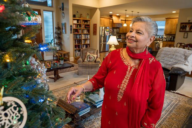 Rachel Thompson/News-Register##Kamalini Kumar of McMinnville, dressed in traditional clothing from India, where she grew up, checks the decorations on her Christmas tree. In her home city of Bangalore, her family would put up a real tree or a tree branch. As Christians, during the holidays they focused on the birth of Christ.