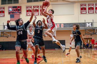 Rusty Rae/News-Register##Senior guard Brayden Mix leaps high above the Parkrose defense to get a running shot off.