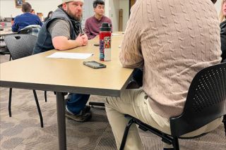 Scott Unger/News-Register##New City Councilor Scott Cunningham, left, talks with City Manager Jeff Towery during a rotating discussion between elected officials and department heads in Saturday’s retreat.