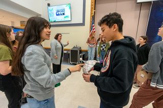 Rachel Thompson/News-Register##Grettel Briseno, left, and Juan Mendoza-Ayala discuss Juan’s tinfoil hat as director Caroline Goin, center, talks production details with the rest of the cast of “The Day the Aliens Attacked Fairfield.” The play runs Thursday and Friday at Duniway.