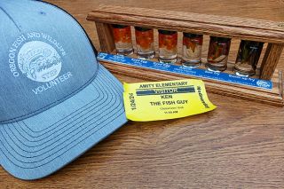 Submitted photo##Ken Dollinger, “the fish guy,” volunteers in local schools as part of the Oregon Fish & Wildlife Department’s Salmon Trout Education Program. The display of jars shows the development of fish from eggs to babies, called “fry.”