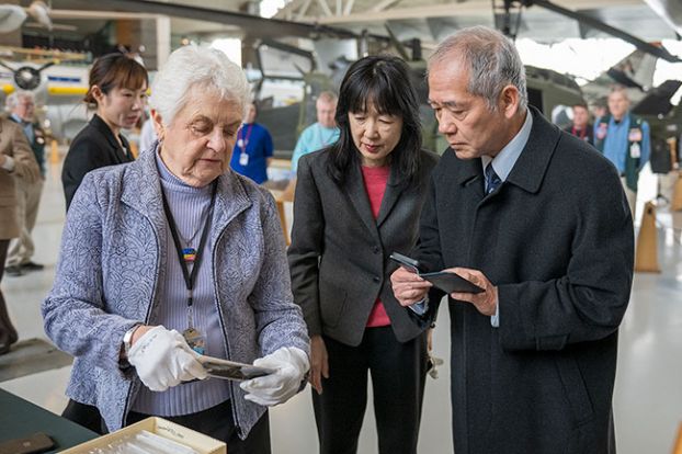 Rusty Rae/News-Register##Collections volunteer Jean Herkamp, left, wearing white protective gloves, shows 80-year-old Japanese correspondence to Consul General Yuzo Yoshioka, right, and Keiko Ziak of the Obon Society, during Wednesday’s ceremony at Evergreen Aviation Museum.