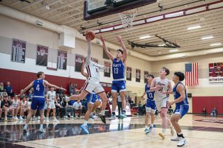 Rachel Thompson/News-Register##Amity’s Kiyan Vrell meets Dayton guard Austin Bodenhamer at the rim to contest the layup attempt during Wednesday night’s close battle between the two county rivals.