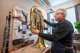 Rachel Thompson/News-Register##Alan Markowitz prepares to work on an Amity High School concert tuba, which he recently buffed out and relacquered in his Horn Doctor repair shop. “Restoring it has been a labor of love,” he said.