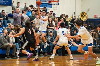 Rachel Thompson/News-Register##Kiyan Vrell (13) snags the ball out of the air and sends it up court to a streaking Austin Carrasco (right) for one of many fast break buckets for the Warriors during their 63-32 victory over Willamina on Friday night.